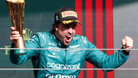 Fernando Alonso celebrating on the podium after securing third place at the Sao Paulo Grand Prix