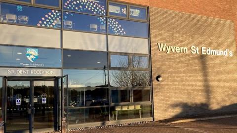 The front of the student reception,a glass and red brick building