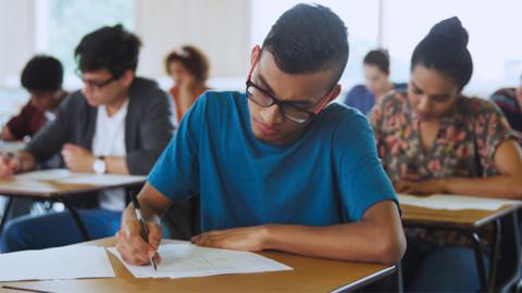 Stock image of college students sitting an exam