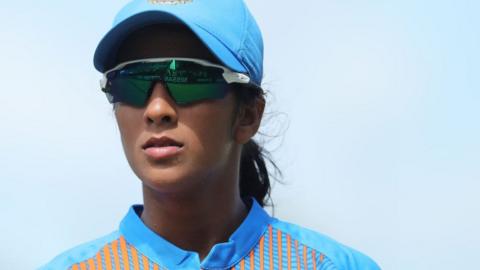 Head shot of Jemimah Rodrigues in her India cricket kit, wearing a light blue cricket cap and wrap around sunglasses