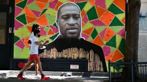 People walk past a mural to George Floyd in New York, June 2020