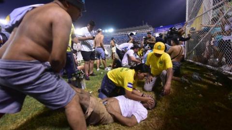 Fans help injured people during a stampede at the Cuscatlán Stadium, during to a soccer match in San Salvador, El Salvador, 20 May 2023.