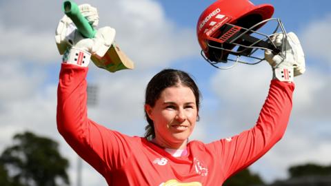 Welsh Fire batter Tammy Beaumont raises her bat and helmet as she walks off after being dismissed for 118