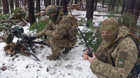 Two soldiers crouching in the snow