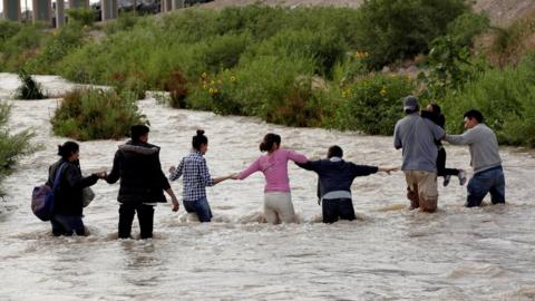 Migrants from Central America form a human chain to cross the Rio Bravo river to enter illegally into the United States to turn themselves in to request for asylum in El Paso, Texas, U.S., as seen from Ciudad Juarez, Mexico June 11, 2019