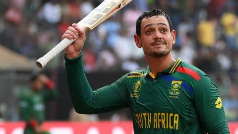 South Africa batter Quinton de Kock raises his bat as he walks off after hitting 174 against Bangladesh