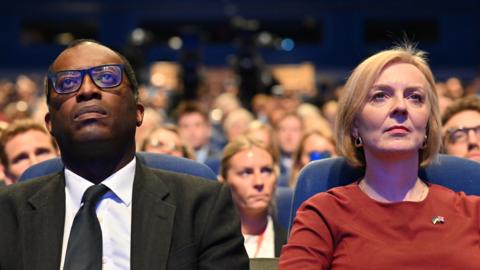 Kwasi Kwarteng sitting next to Liz Truss at the Tory Conference