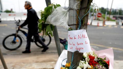 Flowers are seen at the site where Nahel, a 17-year-old teenager, was killed by a French police officer during a traffic stop, in Nanterre, Paris suburb, on 29 June 2023
