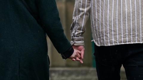 Midshot of couple holding hands