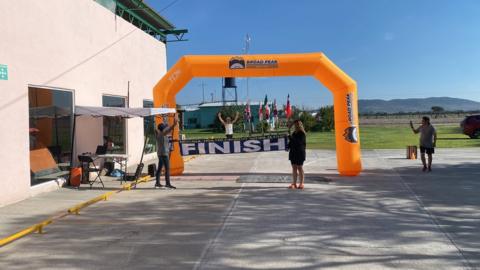 Mr Gillett finishing the Deca Ironman, running through an inflatable arch.