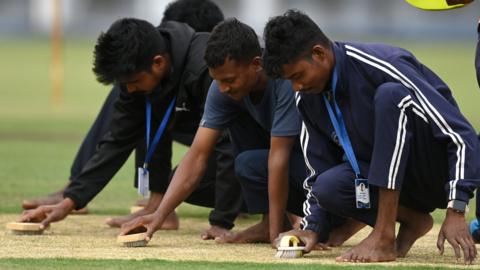 Groundstaff in Ranchi work on the pitch