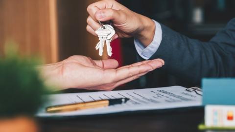 Estate agent giving house keys to woman (stock photo)