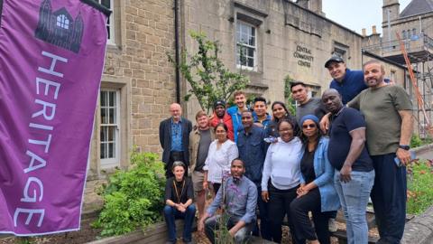 The Global Gardeners standing by their garden