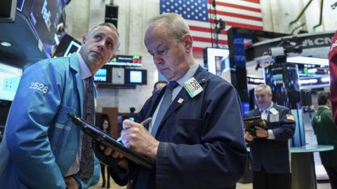 Traders and financial professionals work at the opening bell on the floor of the New York Stock Exchange (NYSE), January 2, 2019 in New York City.
