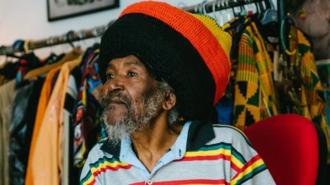 Ras Bandele Selassie wearing red, yellow and green clothing