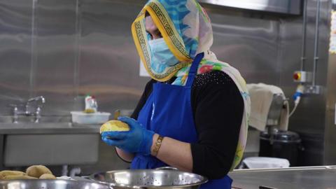 Sikh woman peeling potatoes