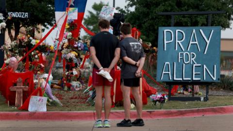 People visit the memorial setup near the scene of a mass shooting at the Allen Premium Outlets mall on May 9, 2023 in Allen, Texas.