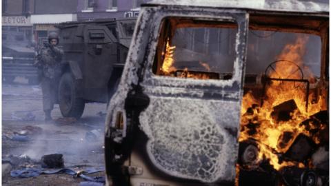 A vehicle burning on a Belfast street circa 1980.