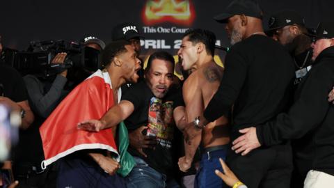 Devin Haney and Ryan Garcia scream at each other during the weigh-in and are held apart by Oscar De La Hoya