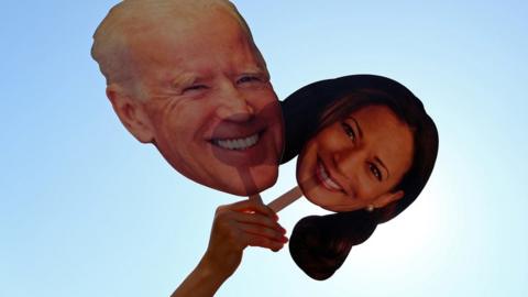 A supporter holds up cutouts of Joe Biden and Kamala Harris near the White House after media announced that Democratic U.S. presidential nominee Joe Biden has won the 2020 U.S. presidential election, in Washington D.C., U.S., November 7, 2020.