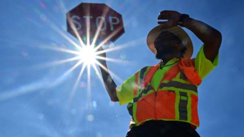 Traffic warden Rai Rogers mans his street corner during an 8-hour shift under the hot sun in Las Vegas, Nevada on July 12, 2023, where temperatures reached 106 degrees amid an ongoing heatwave.