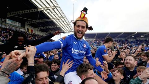 A Chesterfield player with a turkey hat celebrates promotion