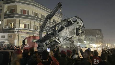 The destroyed car being lifted on a crane