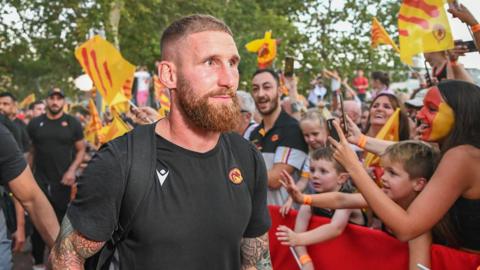 Sam Tomkins makes his way to the ground flanked by fans at the semi-final between Catalans and St Helens