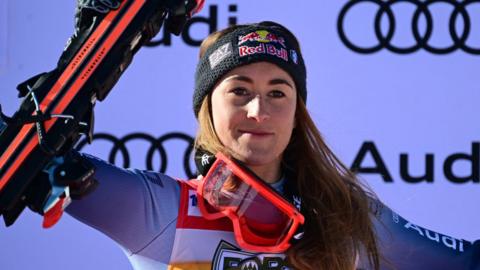 Italy's Sofia Goggia holds her skis aloft