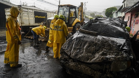 First responders extract a car damaged by a mudslide in El Salvador