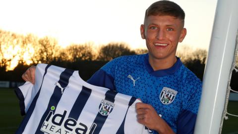 Callum Marshall poses with a West Brom shirt