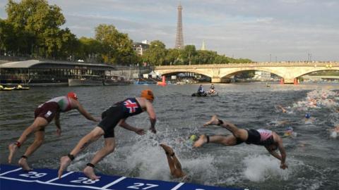 Triathlon athletes dive into The Seine river with the Eiffel Tower in the background during the men's 2023 World Triathlon Olympic Games Test Event in Paris