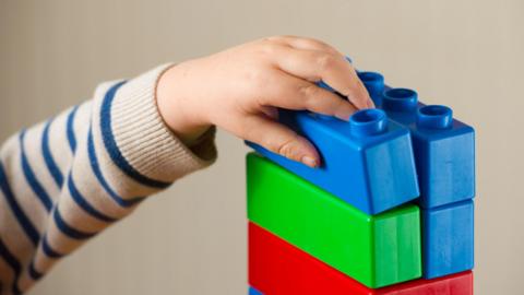 Child's hand with plastic building blocks