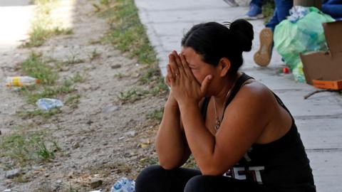 A woman cries outside the morgue of San Pedro Sula, Honduras after the pool hall attack
