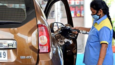 Woman filling fuel at a station in Kolkata, West Bangal