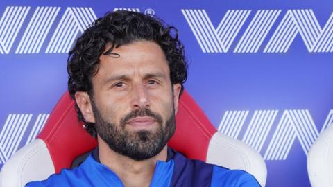 Fabio Grosso sitting in a dugout