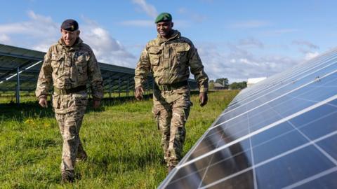 Soldiers walk through a solar farm at the Defence School of Transport (DST) in Leconfield