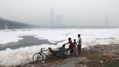 People on the bank of the polluted Yamuna river as the city is engulfed in heavy smog in Delhi, India, 08 November 2023.