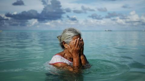 Woman sits in sea
