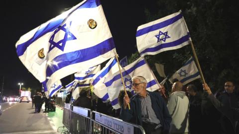 People protest against the Israeli government's judicial overhaul while leaders of the opposition and governing coalition meet at the president's residence in Jerusalem (28 March 2023)