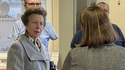 The Princess Royal speaks to a group of people around her indoors, with two mannequins in the corner