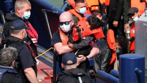 A group of migrants, including children, are brought to Dover on Thursday 3 June