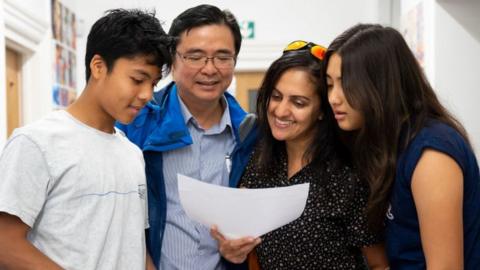 Dhruv Saw opens his GCSE results with family at Ffynone House School in Swansea