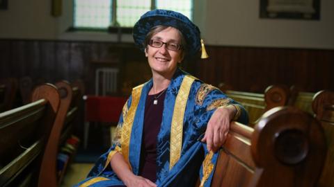 Helen Pankhurst in her blue and gold chancellor gown