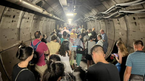 Passengers walk in an emergency tunnel