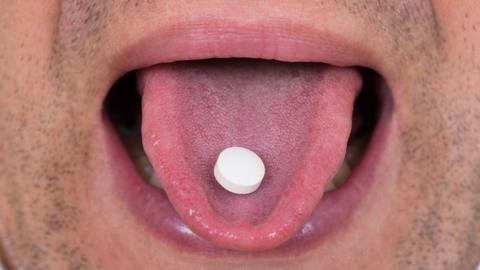 man with a pill on his tongue
