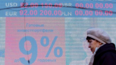 EBRUARY 24, 2022: A woman walks past a digital board displaying the current rates outside a currency exchange office. As of 10am, the Moscow Exchange has reported the US dollar and Euro trading at 89.6 and 99.99 respectively against the Russian rouble, thus reaching their historic highs. Vitaly Nevar/TASS