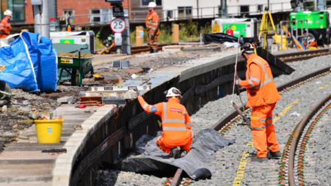 Engineers fixing cooper adjustments on rail line