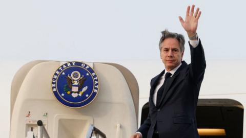US Secretary of State Antony Blinken waves as he boards an airplane to travel to the Philippines from Osan Air Base in Pyeongtaek on March 18, 2024.