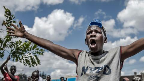 A Kenyan gestures as he protests about the police beating someone during curfew - May 2020